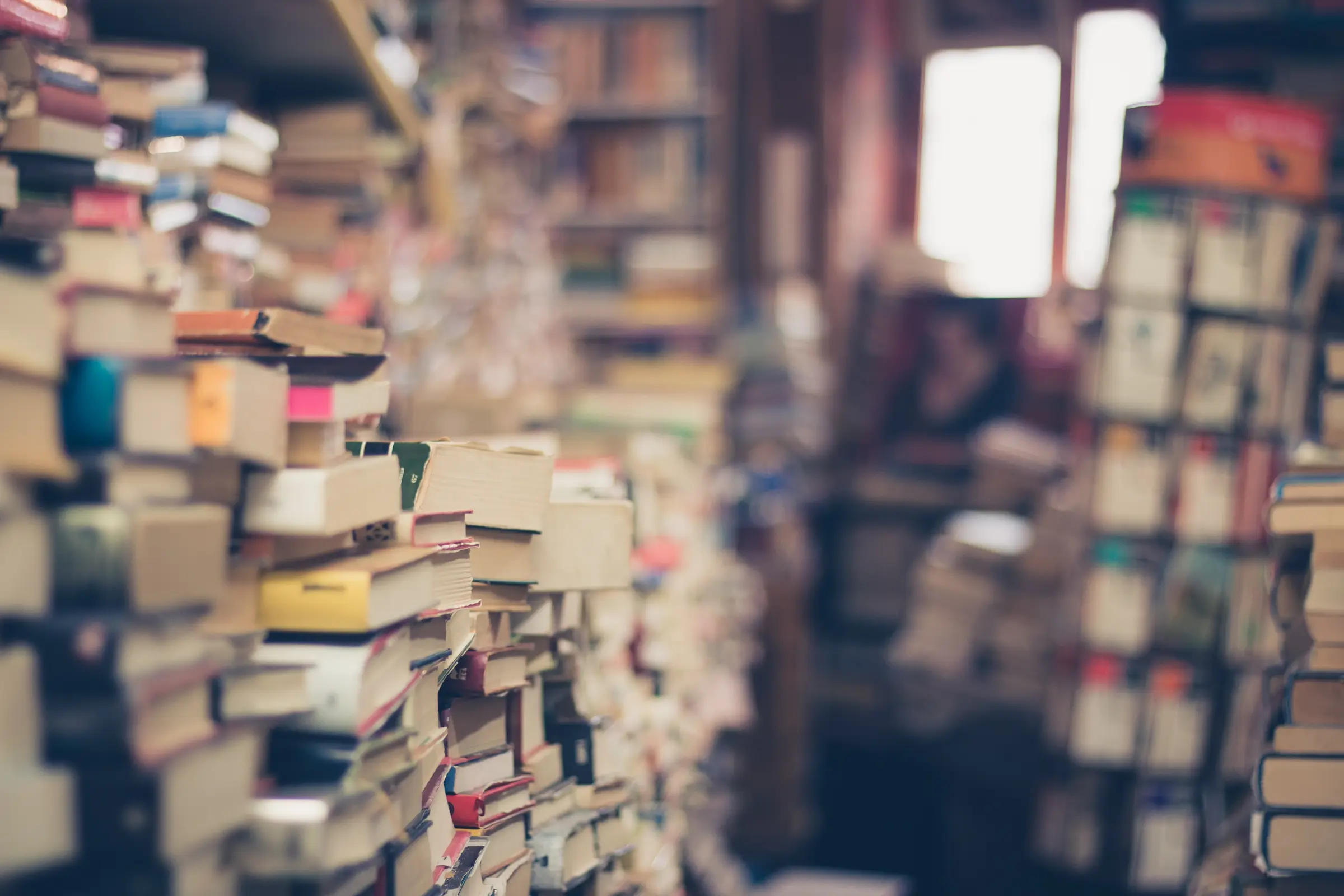 Tall stacks of second-hand books in a crowded bookshop